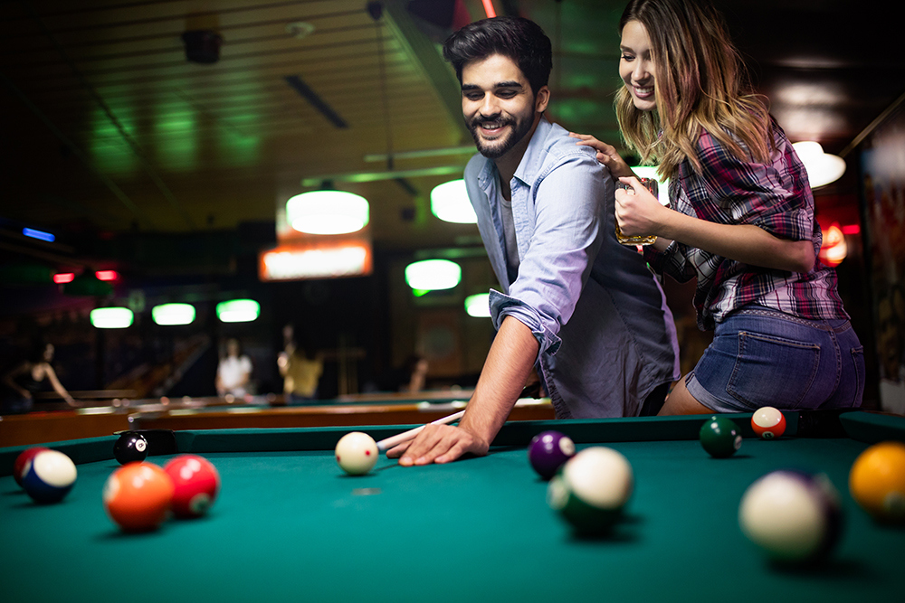 a couple playing pool and being part of the casual dating site community